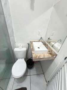 a bathroom with a toilet and a sink at ap 2 quartos com ar e garagem bairro derby in Sobral