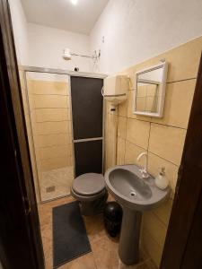 a small bathroom with a toilet and a sink at Ammonite Hostel - Itacaré in Itacaré