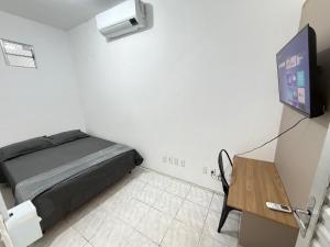 a room with a bed and a tv and a table at ap 2 quartos com ar e garagem bairro derby in Sobral