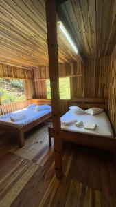a room with two beds in a wooden cabin at Recanto Salto Ano Bom in Corupá