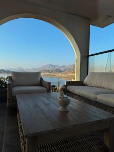 a living room with a table and a view of the ocean at LA SIESTA Suites in Huarmey