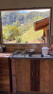 a kitchen with a sink and a view of a mountain at Recanto Salto Ano Bom in Corupá +61 photos