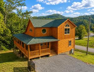 a large wooden cabin with a gambrel roof at Black Bear Lodge in Pigeon Forge
