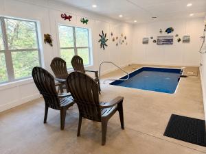 a pool room with chairs and a table and a swimming pool at Black Bear Lodge in Pigeon Forge