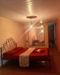 a bedroom with a red bed and a mirror at Motel carioca in Miguel Pereira