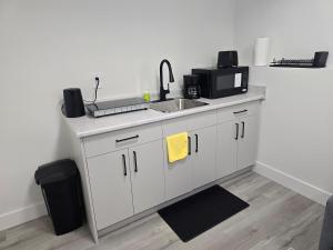 a kitchen with a sink and a microwave at The Vilaskan in Saskatoon +5 photos