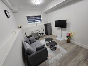 a living room with a couch and a tv at The Vilaskan in Saskatoon