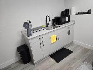 a kitchen counter with a sink and a microwave at The Vilaskan in Saskatoon