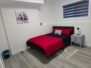 a bedroom with a bed with a red blanket at The Vilaskan in Saskatoon
