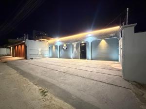 an empty street at night with lights on a building at Ap no Derby com garagem e ar in Sobral