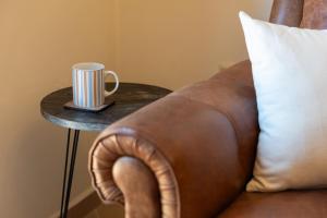 a coffee mug sitting on a table next to a couch at Villa Katerina BBQ & pool! in Metaxáta +2 photos