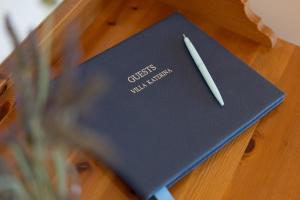 a pen sitting on top of a book on a table at Villa Katerina BBQ & pool! in Metaxáta
