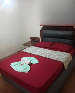 a bedroom with a bed with two robes on it at Motel carioca in Miguel Pereira