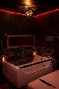 a bath tub in a room with red lights at bucharest love room in Bucharest