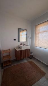 a bathroom with a sink and a mirror at LA SIESTA Suites in Huarmey