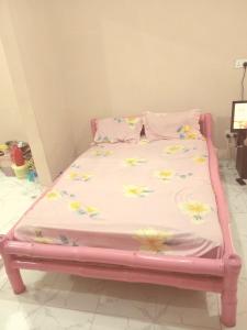 a pink bed with flowers on it in a room at Bed and breakfast, diner available in Djalabango