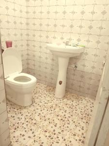a bathroom with a toilet and a sink at Bed and breakfast, diner available in Djalabango