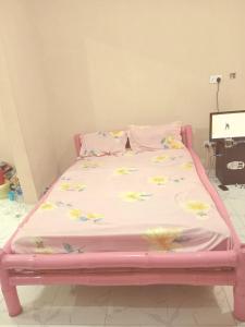 a pink bed with flowers on it in a room at Bed and breakfast, diner available in Djalabango