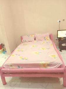 a pink bed with flowers on it in a room at Bed and breakfast, diner available in Djalabango