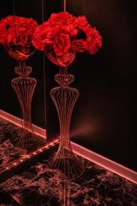 two vases with red flowers in them on a table at bucharest love room in Bucharest