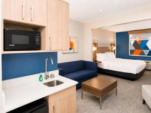 a hotel room with a bed and a kitchen at Holiday Inn Express & Suites Truth or Consequences by IHG - Newly Renovated in Truth or Consequences