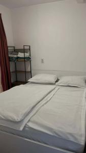 a bed with white sheets and pillows on it at Mobile Home ABC in Donji Karin