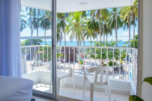 una stanza con balcone con palme e vista sull'oceano di Hotel Be La Sierra a Santa Marta
