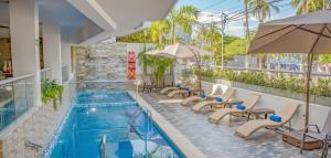 una piscina con sedie e ombrelloni su un edificio di Hotel Be La Sierra a Santa Marta