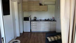 a small kitchen with white appliances and wooden cabinets at Mobile Home ABC in Donji Karin +1 photo