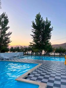 a swimming pool with a checkered floor and trees at Mobile Home ABC in Donji Karin