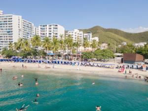 un gruppo di persone in acqua su una spiaggia di Hotel Be La Sierra a Santa Marta