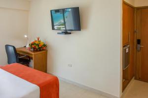 una stanza con un letto, una scrivania e una TV sul muro di Hotel Be La Sierra a Santa Marta Altre 19 foto