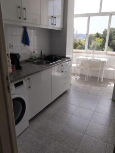 a kitchen with a sink and a washing machine at The Tram 18 Space in Lisbon