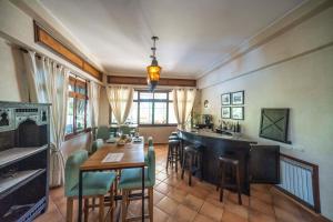 a dining room with a bar and a table and chairs at Studio Appartement Perdicaris en rez de jardin - maison dhotes Dar Tanja in Tangier