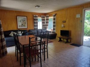a living room with a table and chairs and a couch at Tu Refugio Natural en Mahuida in Pucón