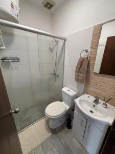 a bathroom with a toilet and a shower and a sink at La Casona Posada in Florencio Sánchez
