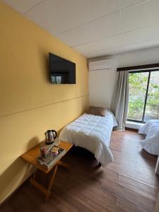 a bedroom with a bed and a table and a tv at La Casona Posada in Florencio Sánchez