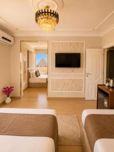a bedroom with two beds and a chandelier at Miami Pyramids View in Cairo