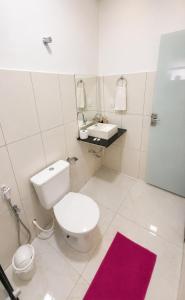 a bathroom with a white toilet and a sink at Pousada Jeitim Mineiro in Capitólio +27 photos