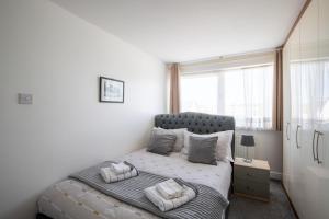a bedroom with a large bed with pillows on it at Spacious 5Bedroom Home with Garden & Parking Sleeps 11 Near Elizabeth Line in Goodmayes