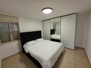 a bedroom with a large bed and a mirror at פנינת הצפון in Qiryat Shemona