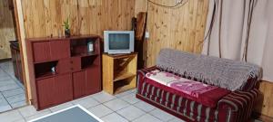 a living room with a couch and a tv at Cabaña Don Jorge in Puerto Rico