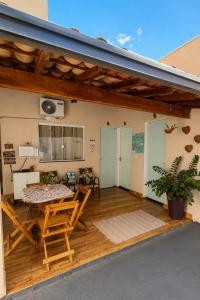 a patio with a table and chairs on a deck at Pousada Jeitim Mineiro in Capitólio