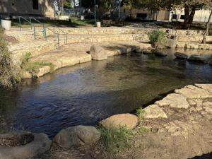 a stream of water with rocks in a park at פנינת הצפון in Qiryat Shemona
