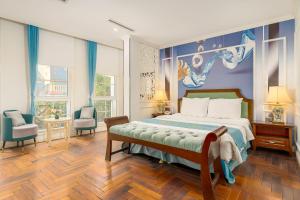 a bedroom with a bed with a painting on the wall at Hanoi Maro Hotel in Hanoi