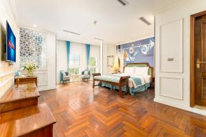 a bedroom with a bed and a wooden floor at Hanoi Maro Hotel in Hanoi