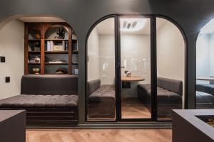 a room with glass walls and a couch and a table at The Urban Muse suite in Mexico City