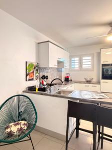 a kitchen with a sink and a table and chairs at Kessydryss in Sainte-Marie
