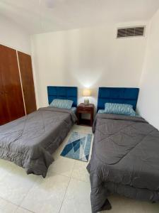 a bedroom with two beds and a table with a lamp at puerto real isla de margarita in La Playa +4 photos