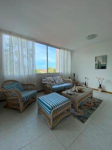 a living room with wicker furniture and a large window at puerto real isla de margarita in La Playa